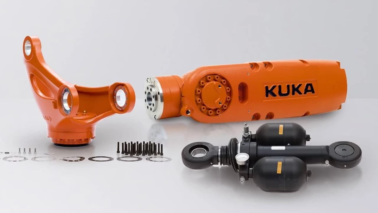 Industrial robot arm components, gas spring balancer, bolts and shims laid out for maintenance