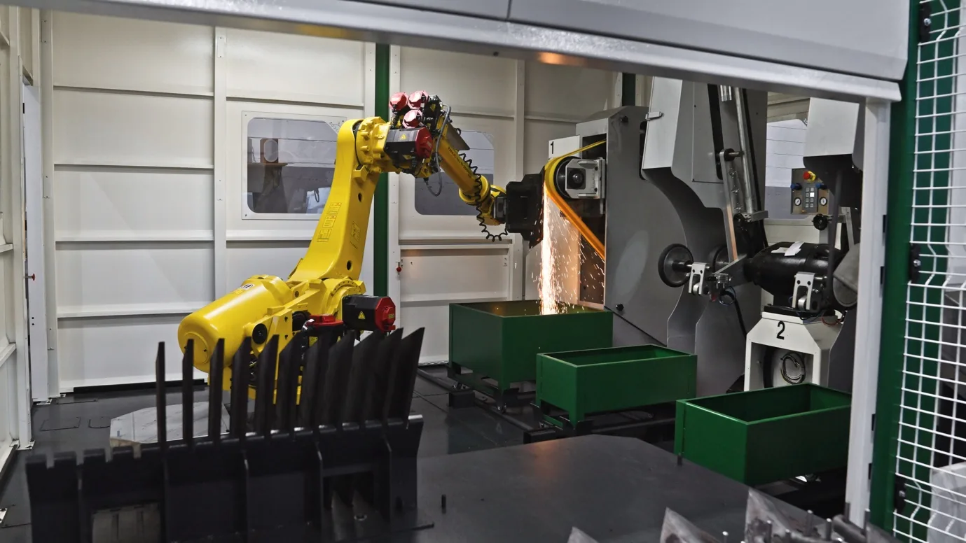Industrial robot grinding a metal component against a belt finishing machine