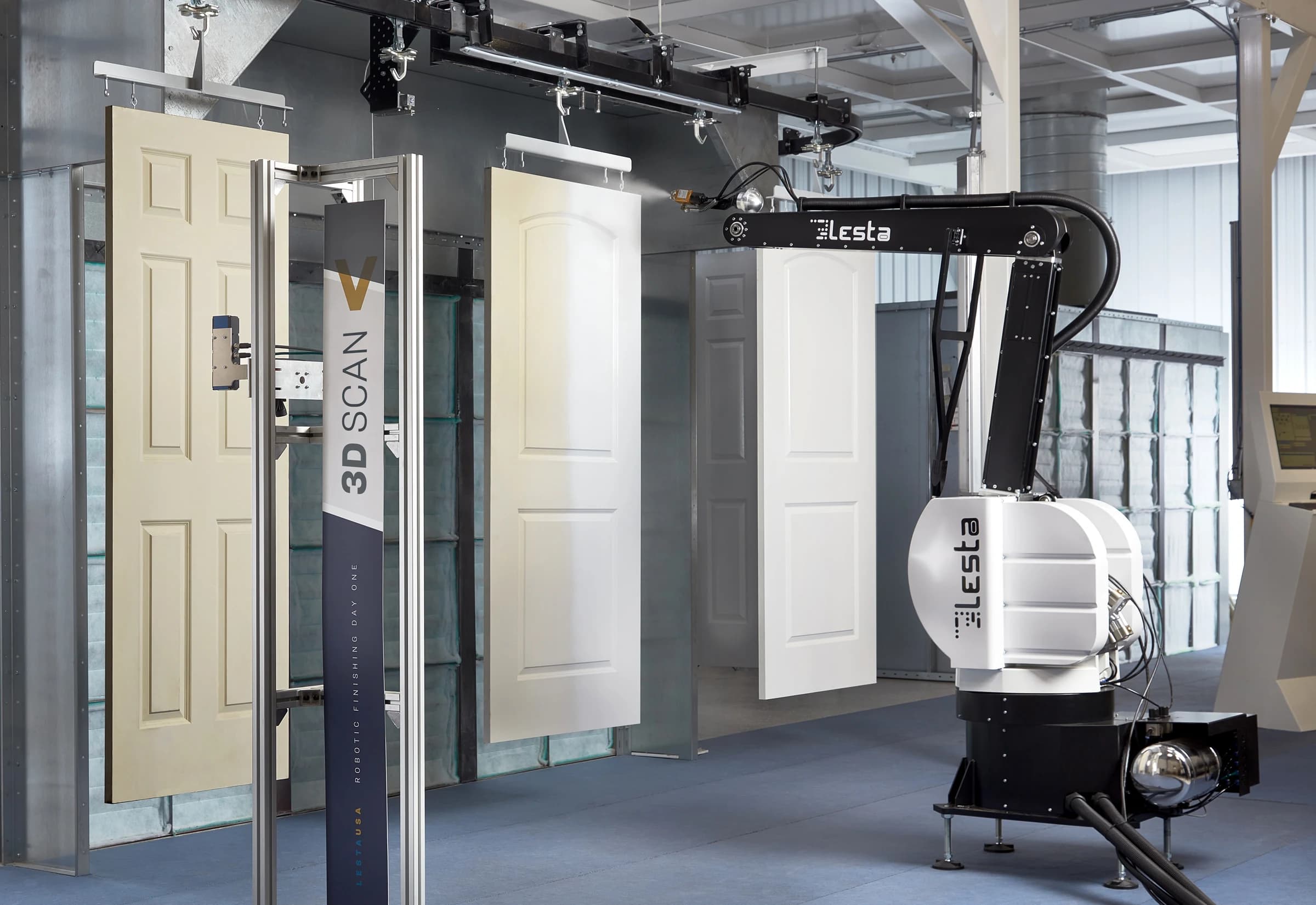 Robotic painting system coating suspended doors inside an automated paint booth